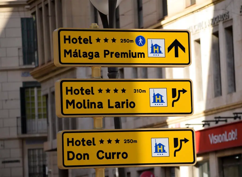 Three signs indicating Malaga hotels directions